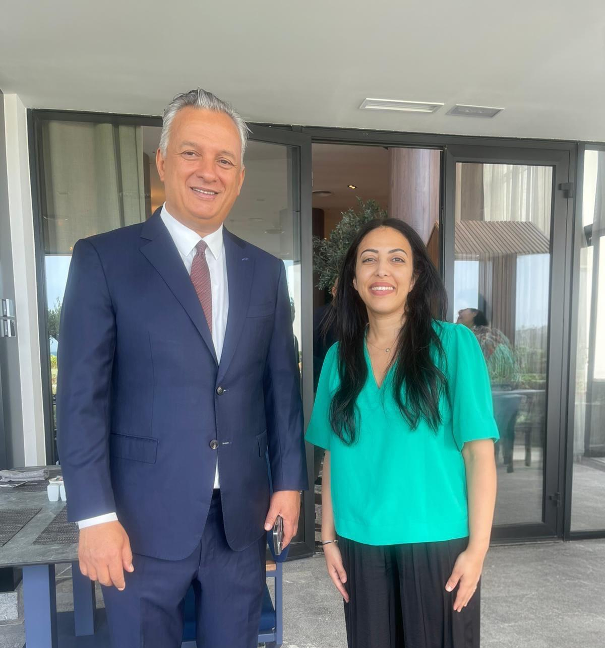 Le Dr Sana Amraoui, en haut vert, aux côtés d’un participant en costume bleu marine, en marge du Forum National de l’Investissement des Marocains du Monde à Tanger