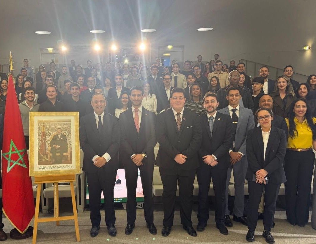 Photo de groupe de la rencontre : le Ministre Ryad Mezzour entouré des participants, devant le drapeau marocain et le portrait de Sa Majesté le Roi Mohammed VI