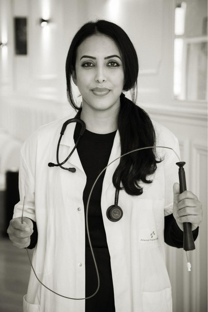 Le Dr Sana Amraoui en blouse médicale, instruments à la main, dans son cabinet de rythmologie